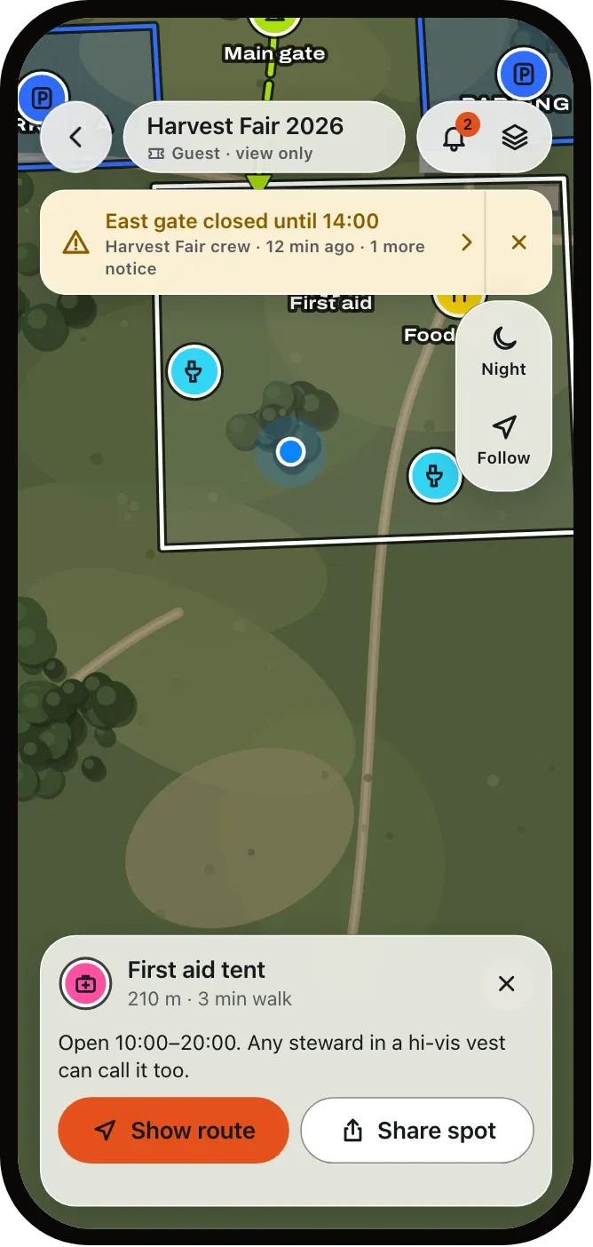 A guest’s phone showing the Harvest Fair map with a notice that the east gate is closed until 14:00, and the first aid tent 210 m away.
